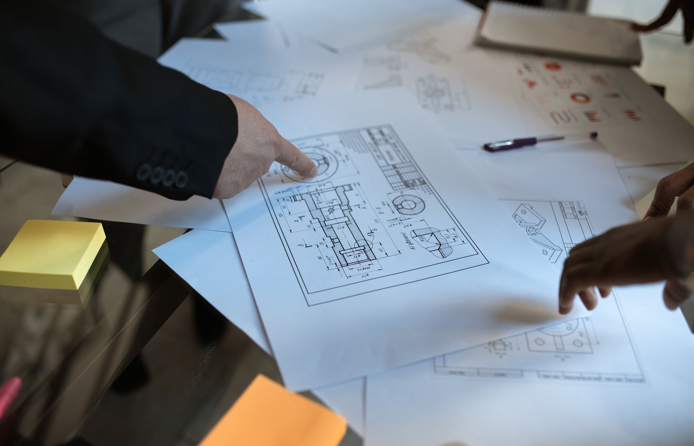 Two engineers reviewing structural drawings on a light table